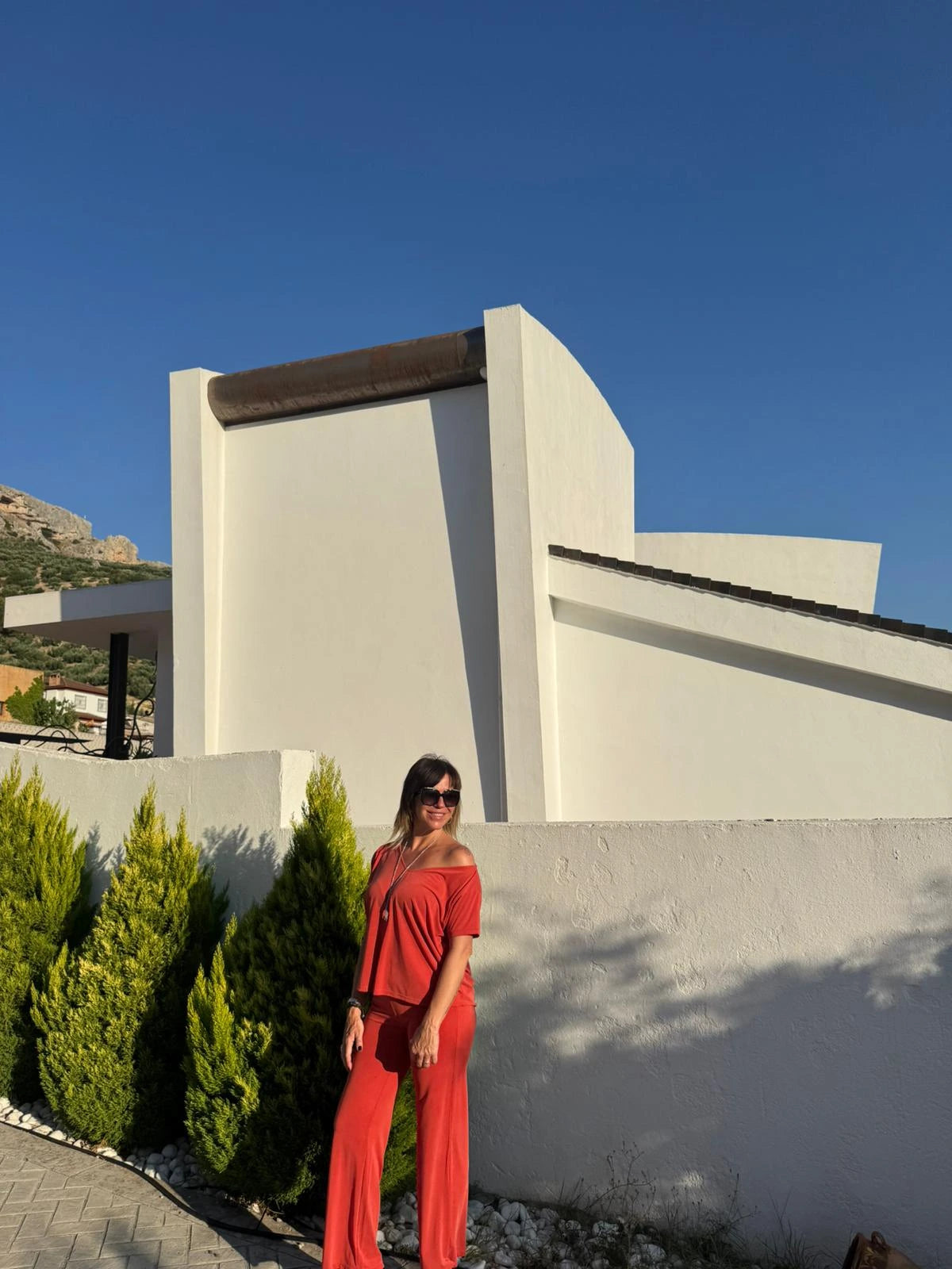 Pose lateral con la camiseta de manga corta color naranja