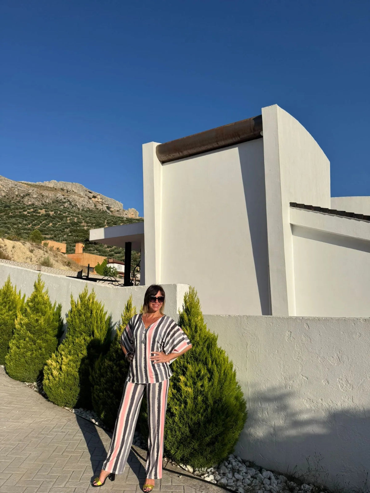 Conjunto de blusa más pantalón con estampado a rayas verticales en tonos claros (negro, gris, blanco y rosa)