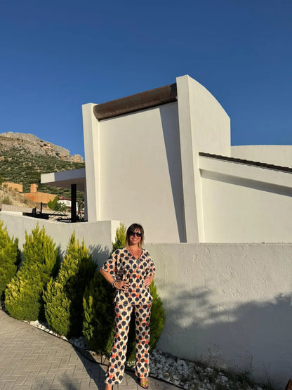 Conjunto Queen formado por una blusa y un pantalón con estampado floral en tonos naranja y negro