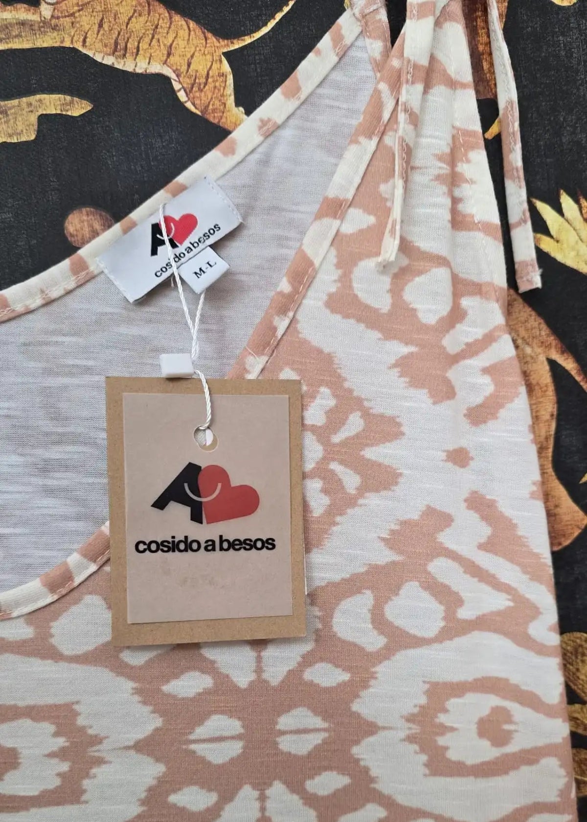 Destalles de un vestido de tirantes con bajo en volantes y estampado geométrico