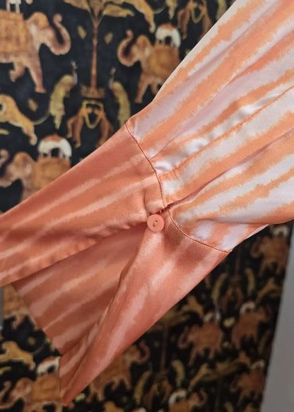 Detalle de la manga del vestido largo ovalado color naranja sunset con estampado vertical efecto degradado